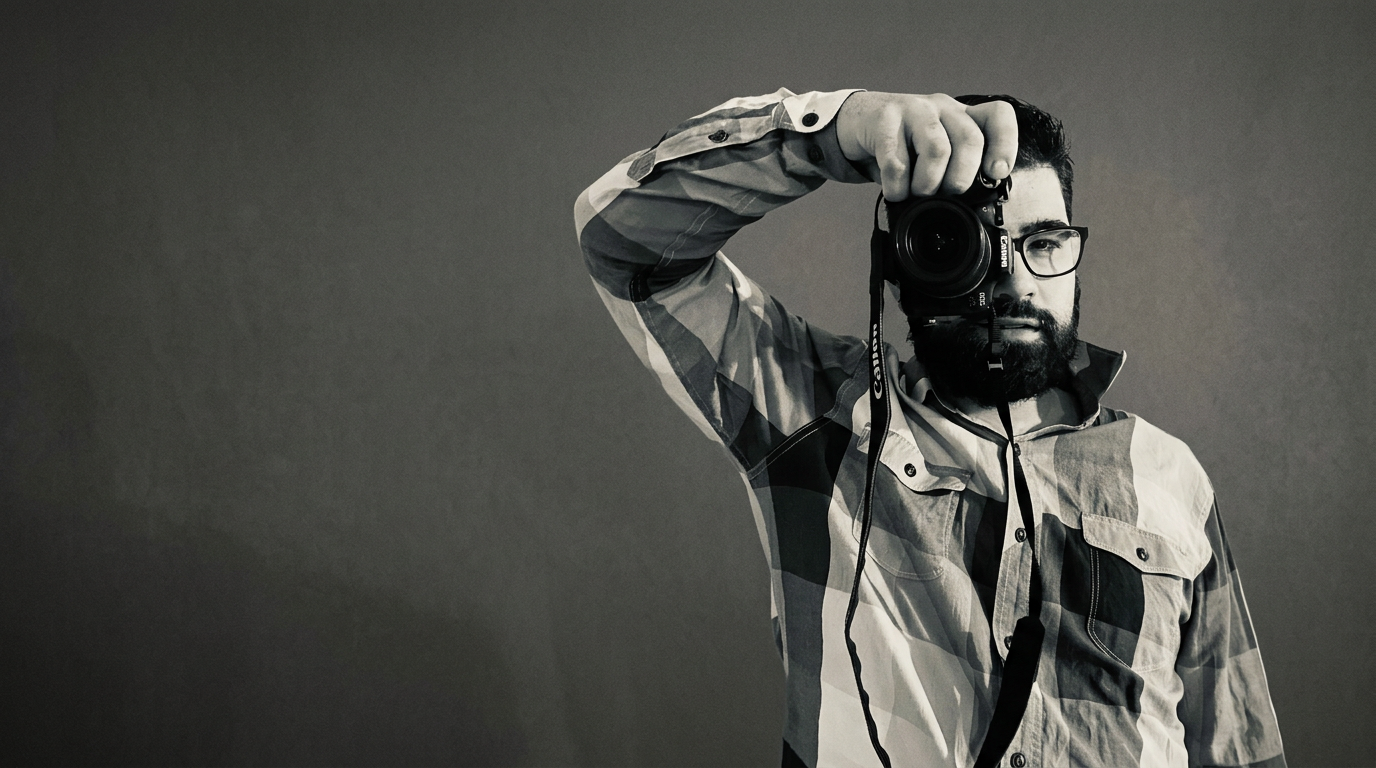 Romain, photographe, derrière son appareil photo en noir et blanc